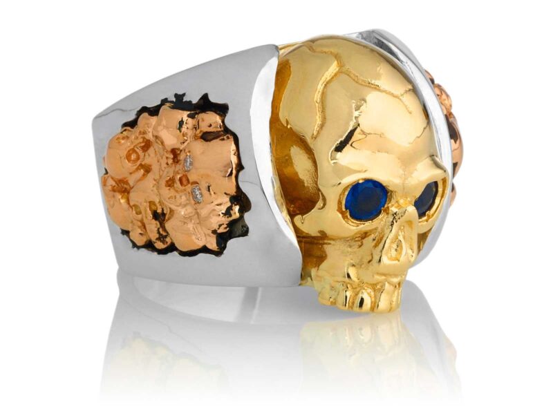 RG1030YGSIL-B Judge and Jury Skull Ring (Right Side View) in Yellow Gold and Sterling Silver with Blue Sapphires and White Diamonds, designed by Steve Soffa