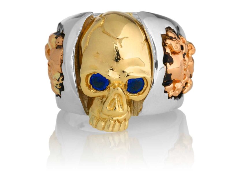 RG1030YGSIL-B Judge and Jury Skull Ring (Front View) in Yellow Gold and Sterling Silver with Blue Sapphires and White Diamonds, designed by Steve Soffa