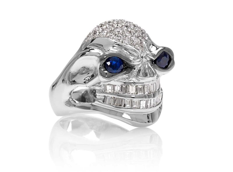 RG3026WG-A Vicious Vinnie Skull Ring (Front Side View) in White Gold with White Diamonds and Blue Sapphires, designed by Steve Soffa